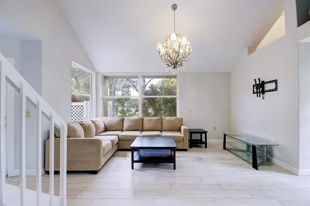 a living room with furniture chandelier and a table