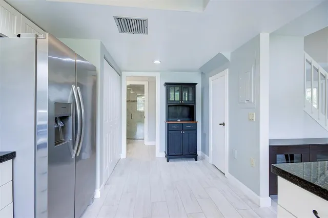 a view of a hallway with wooden floor and a living room
