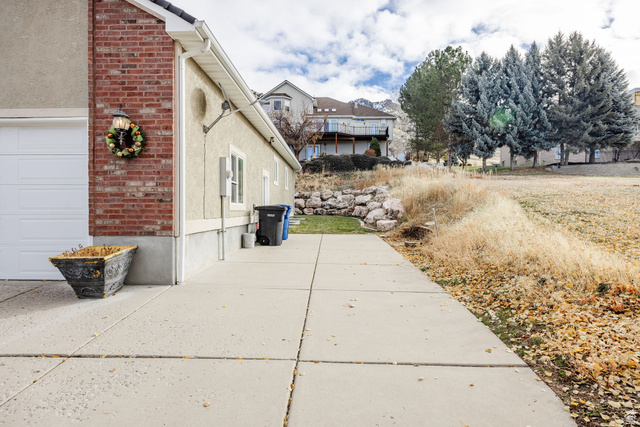 240 Bugle Way Providence, UT 84332 - Photo 4 of 15 Concrete driveway leading to an attached garage with a white sectional door