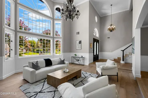 a living room with furniture a fireplace and a large window