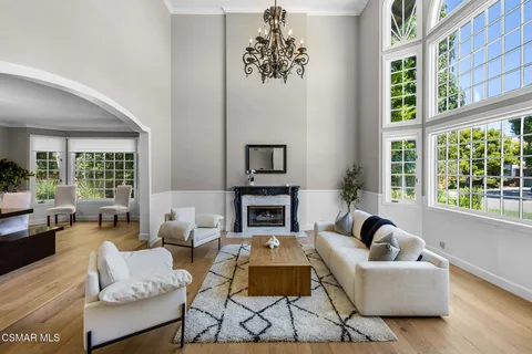a dining room with furniture a chandelier and wooden floor