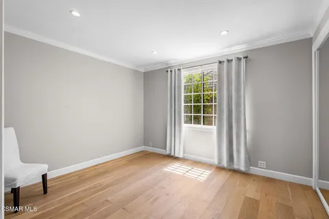 a living room with stainless steel appliances kitchen island granite countertop a refrigerator oven a sink dishwasher and white cabinets with wooden floor