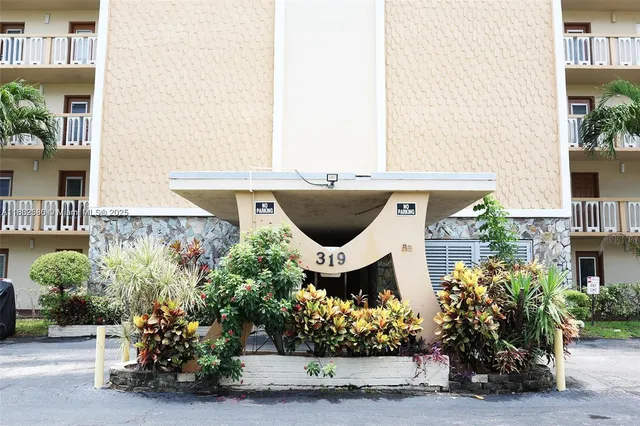 a front view of a house with a yard and a fountain