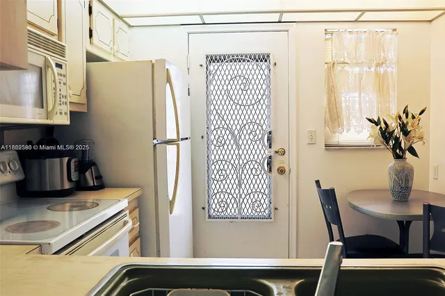 a kitchen with a refrigerator and table chair
