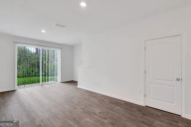 a view of a big room with wooden floor and windows