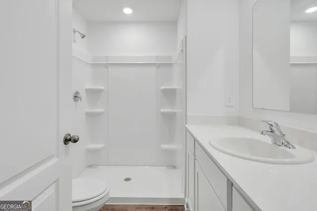 a bathroom with a sink a toilet and shower