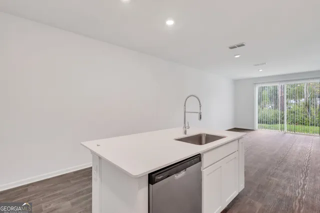 a kitchen that has a sink and a wooden floor