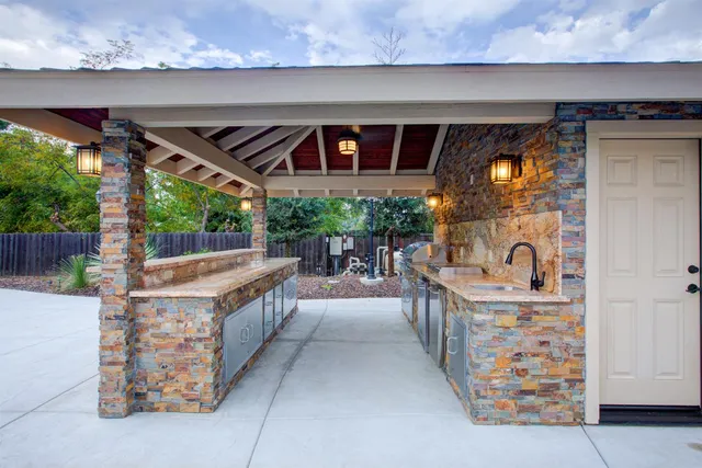 a kitchen with stainless steel appliances granite countertop a sink and a stove