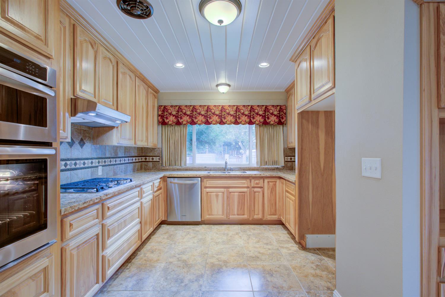1739 First Street Atwater, CA 95301 - Photo 26 of 58 a kitchen with stainless steel appliances granite countertop a stove a sink and a microwave