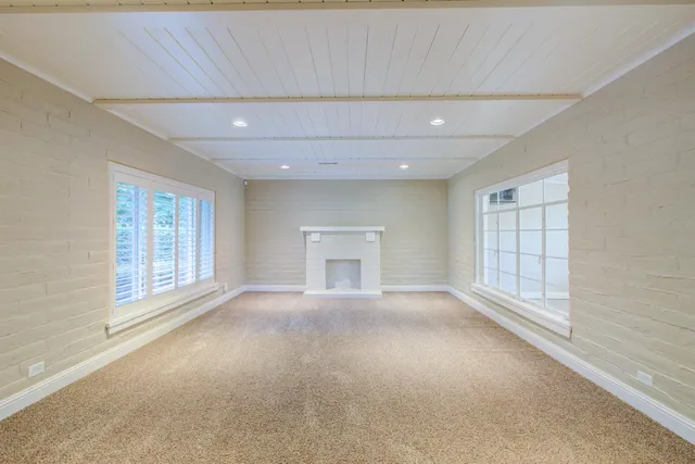 a view of an empty room with a fireplace and a window