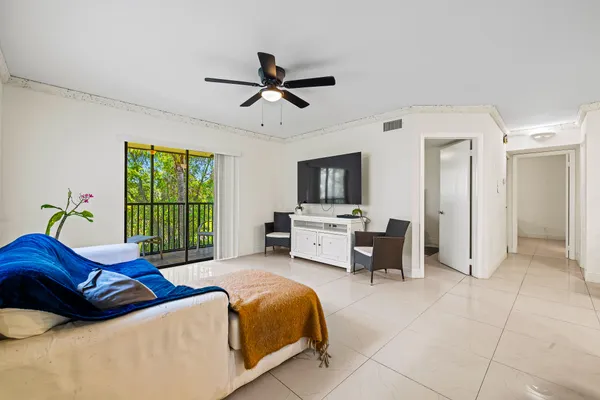 a bedroom with a bed a window and a flat screen television