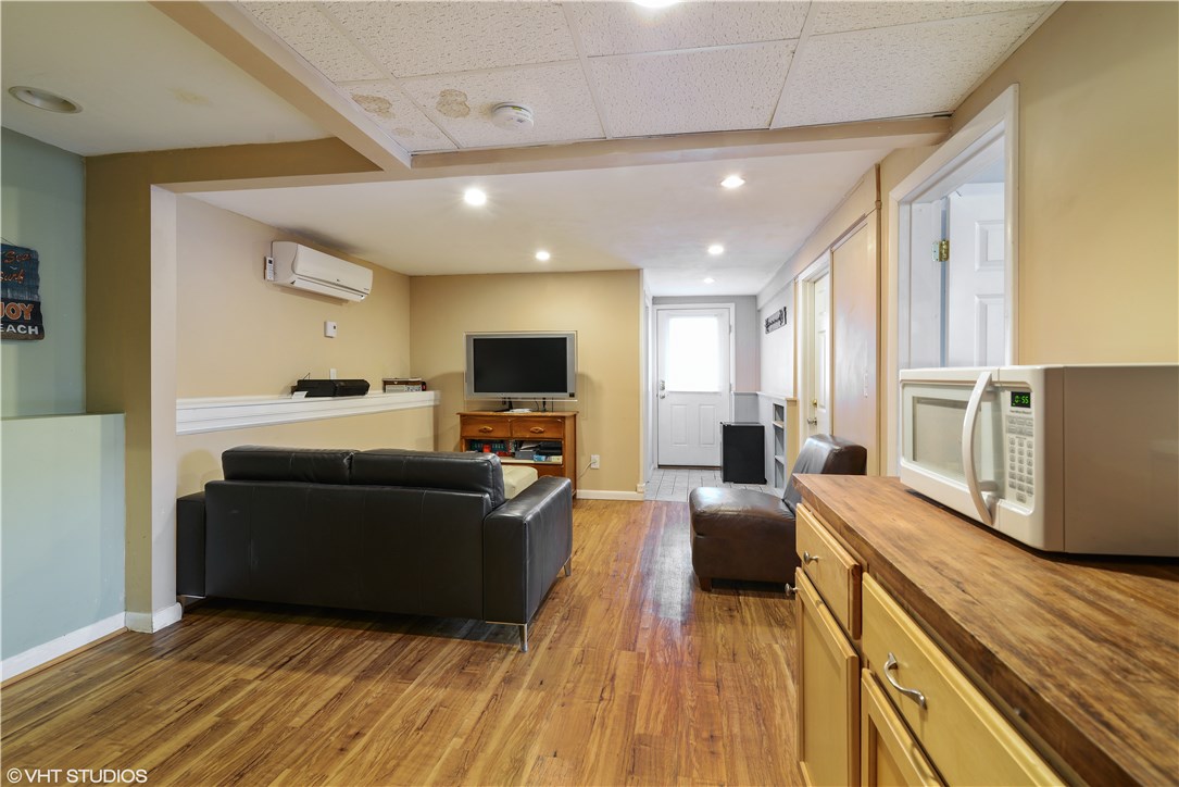 46 Conanicut Road Narragansett, RI 02882 - Photo 14 of 36 The lower level family room has a kitchenette at the near end and a full bath and walkout at the far end. Two bedrooms, one of which is a master with an ensuite bathroom, are on the right.