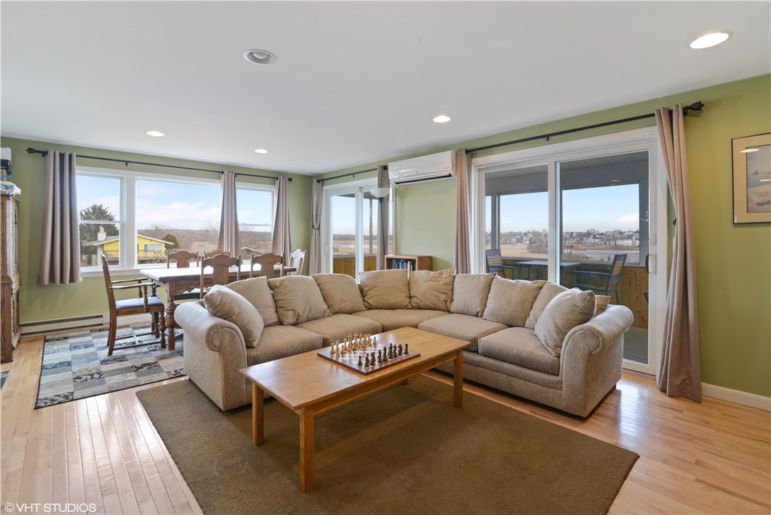 46 Conanicut Road Narragansett, RI 02882 - Photo 4 of 36 The open flow living/dining area has views of Wesquage Pond and the bay. The sliders lead to the screened-in porch