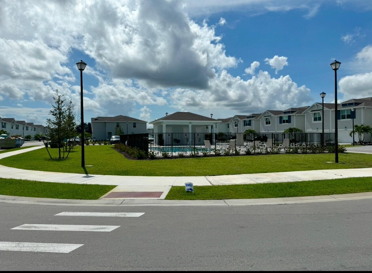 5786 Southeast Edgewater Circle Stuart, FL 34997 - Photo 2 of 15 a view of a fountain in front of a brick house