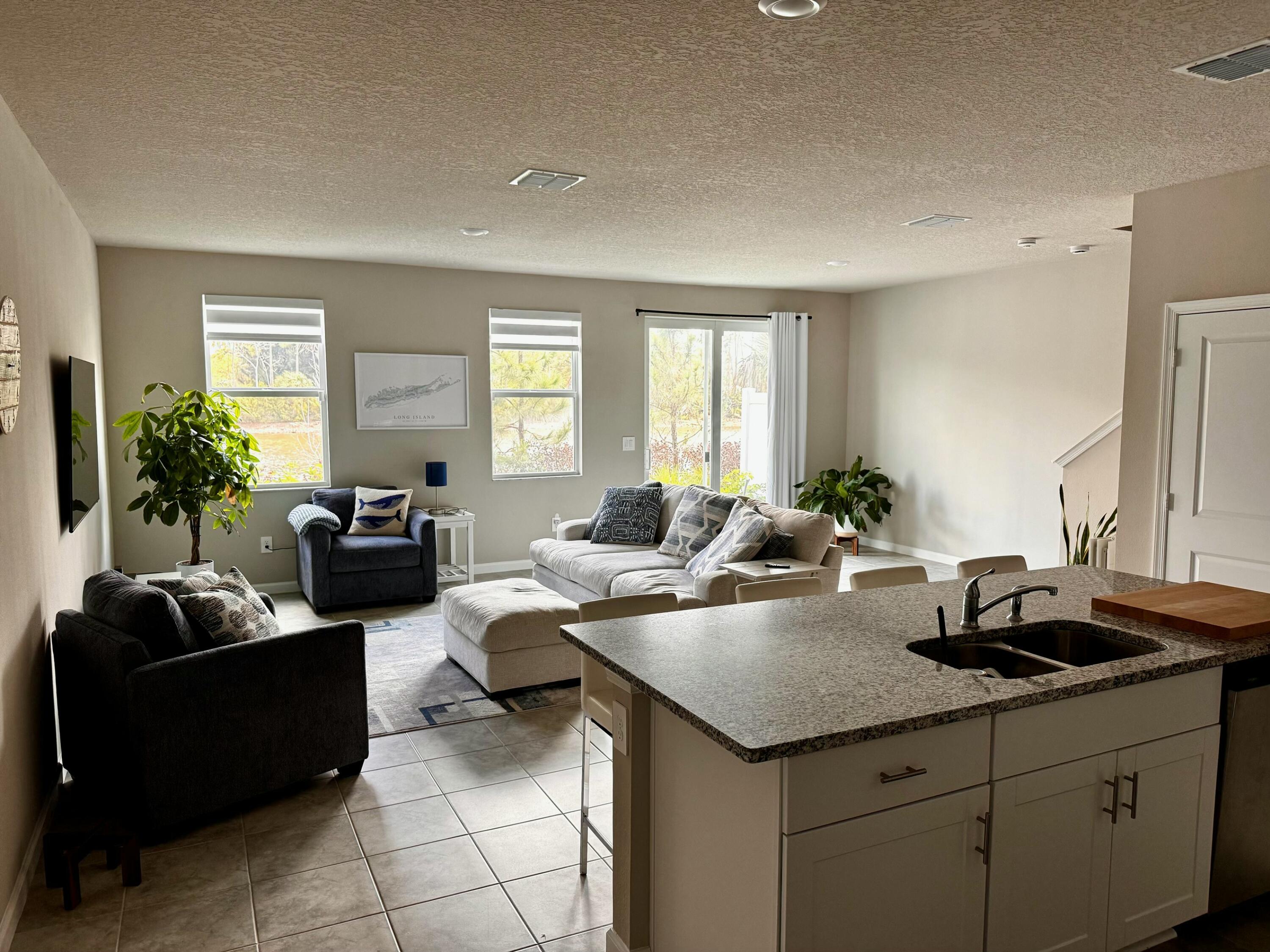 5786 Southeast Edgewater Circle Stuart, FL 34997 - Photo 5 of 15 a living room with kitchen island furniture and a potted plant