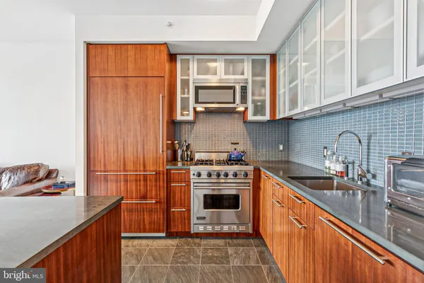 a kitchen with stainless steel appliances granite countertop a stove sink and cabinets