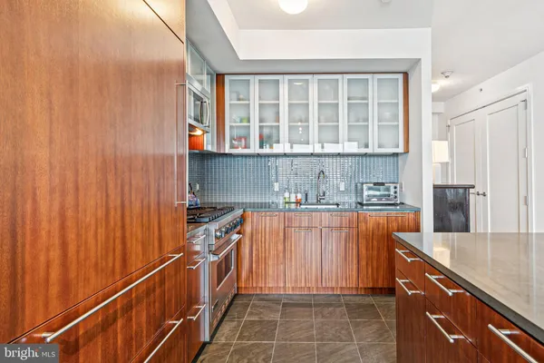 a kitchen with stainless steel appliances granite countertop a sink and a refrigerator