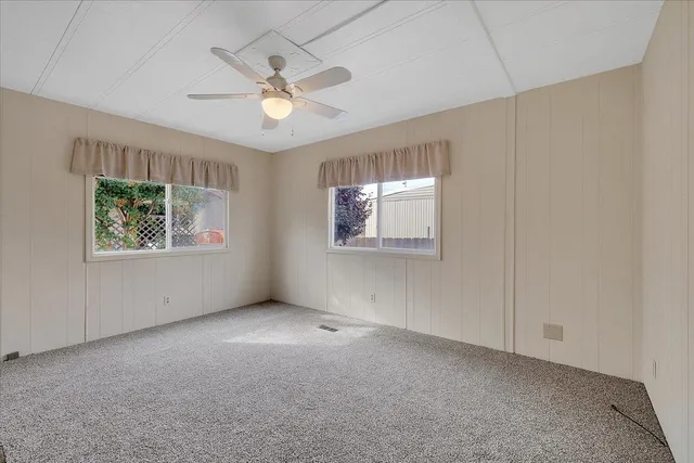 a view of an empty room with a chandelier fan