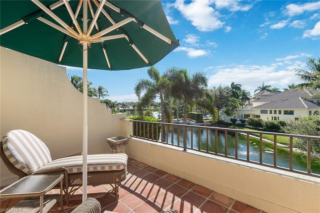 8063 Vizcaya Way Naples, FL 34108 - Photo 16 of 28 a view of a patio with a table and chairs under an umbrella