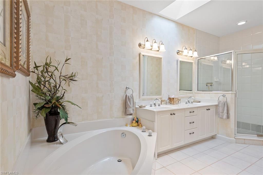 8063 Vizcaya Way Naples, FL 34108 - Photo 17 of 28 a bathroom with a bathtub sink and mirror