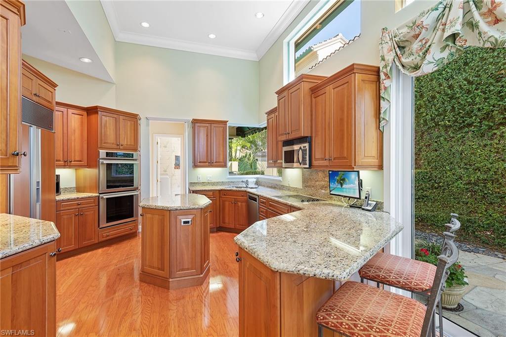 8063 Vizcaya Way Naples, FL 34108 - Photo 7 of 28 a kitchen with stainless steel appliances granite countertop a sink and a refrigerator