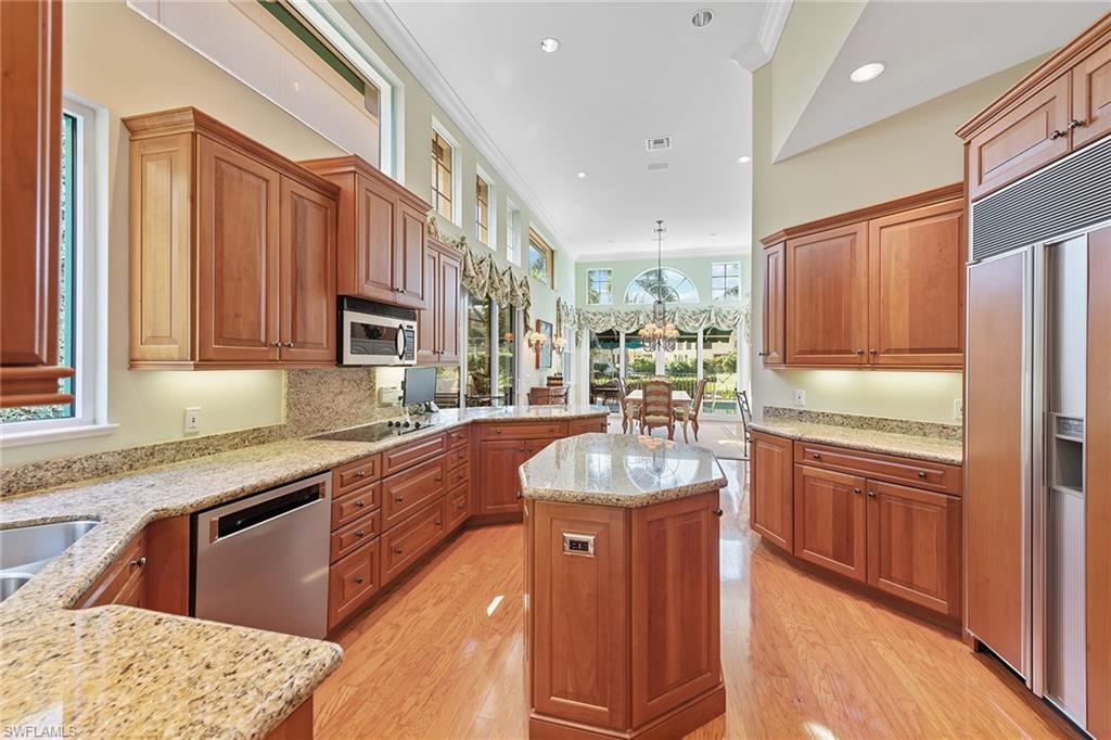 8063 Vizcaya Way Naples, FL 34108 - Photo 8 of 28 a large kitchen with stainless steel appliances granite countertop a sink and wooden cabinets