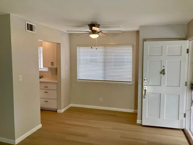 a view of a room with a large window and front door