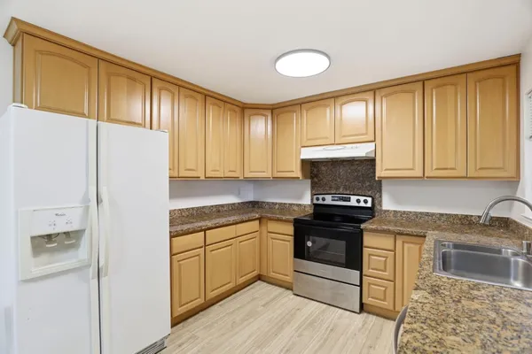 a kitchen with a refrigerator sink and cabinets