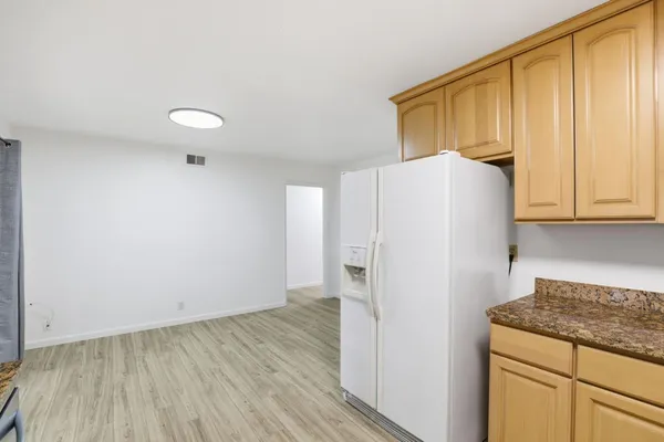 a view of a kitchen with wooden floor and cabinets