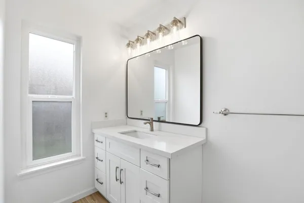 a bathroom with a sink a mirror and a vanity