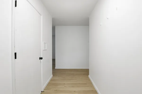 a view of a hallway with wooden floor