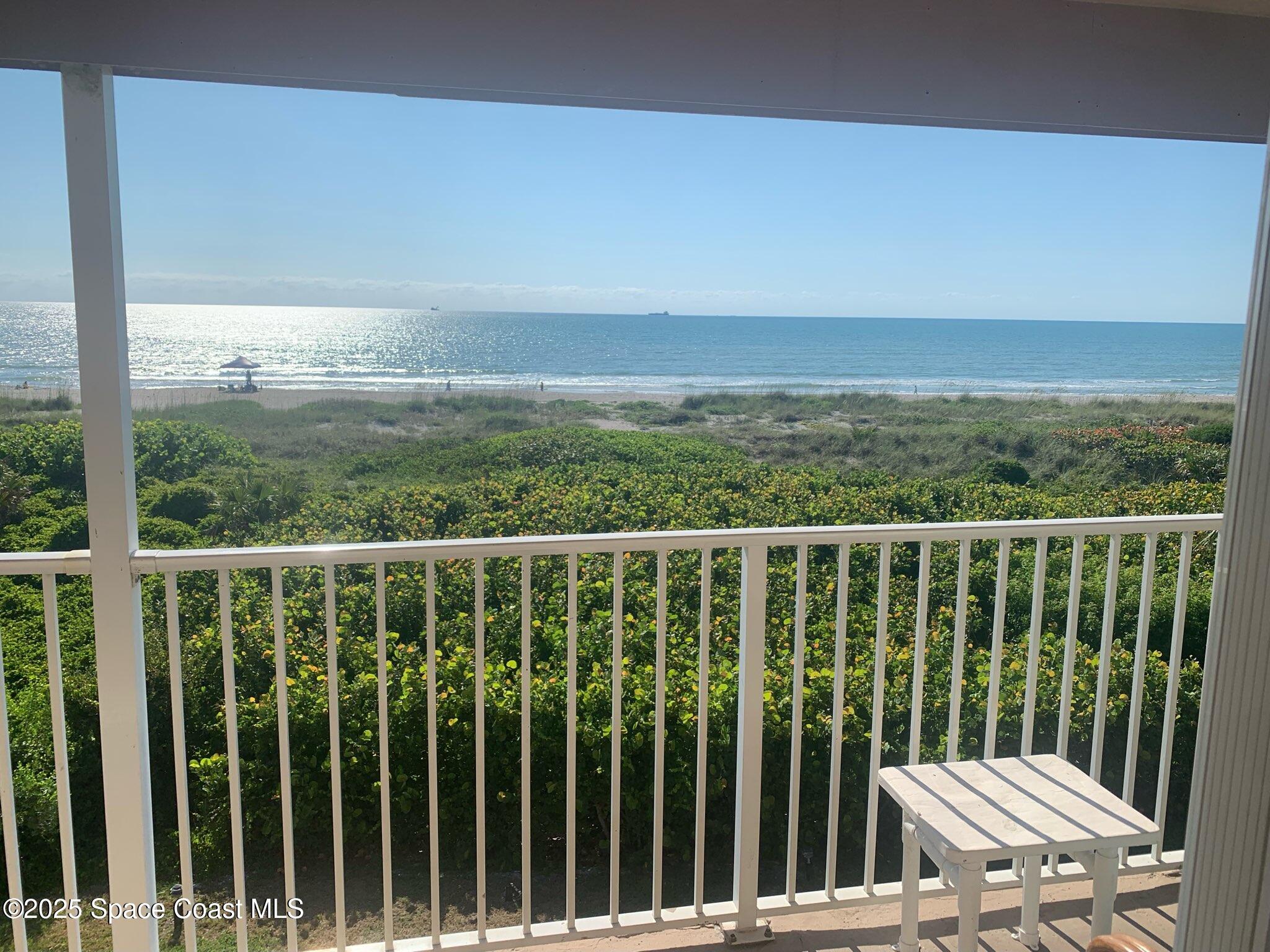 a view of a balcony with wooden floor & fence