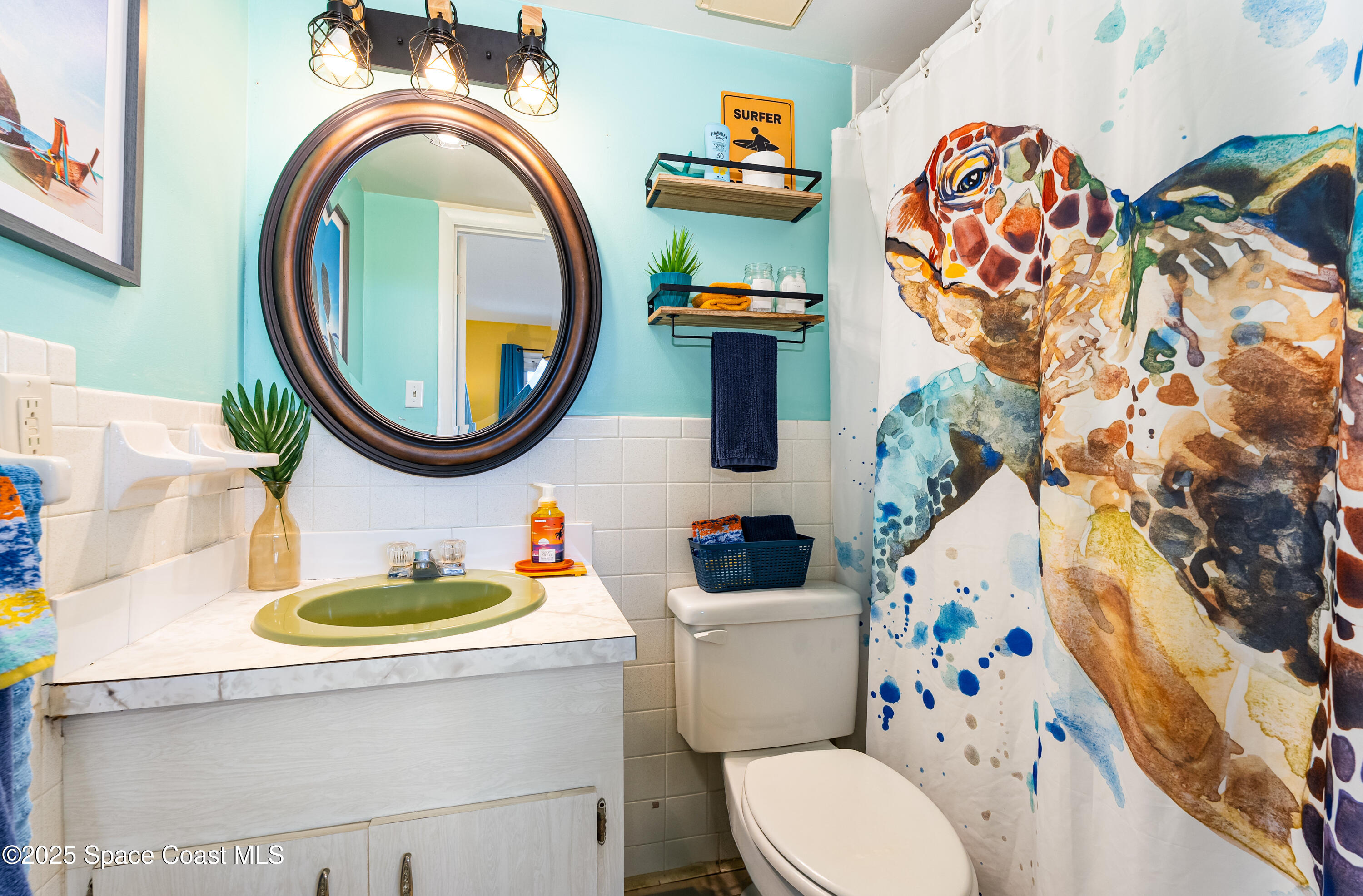 3150 North Atlantic Avenue, Unit 11550 Cocoa Beach, FL 32931 - Photo 14 of 30 a bathroom with a toilet a sink and a mirror