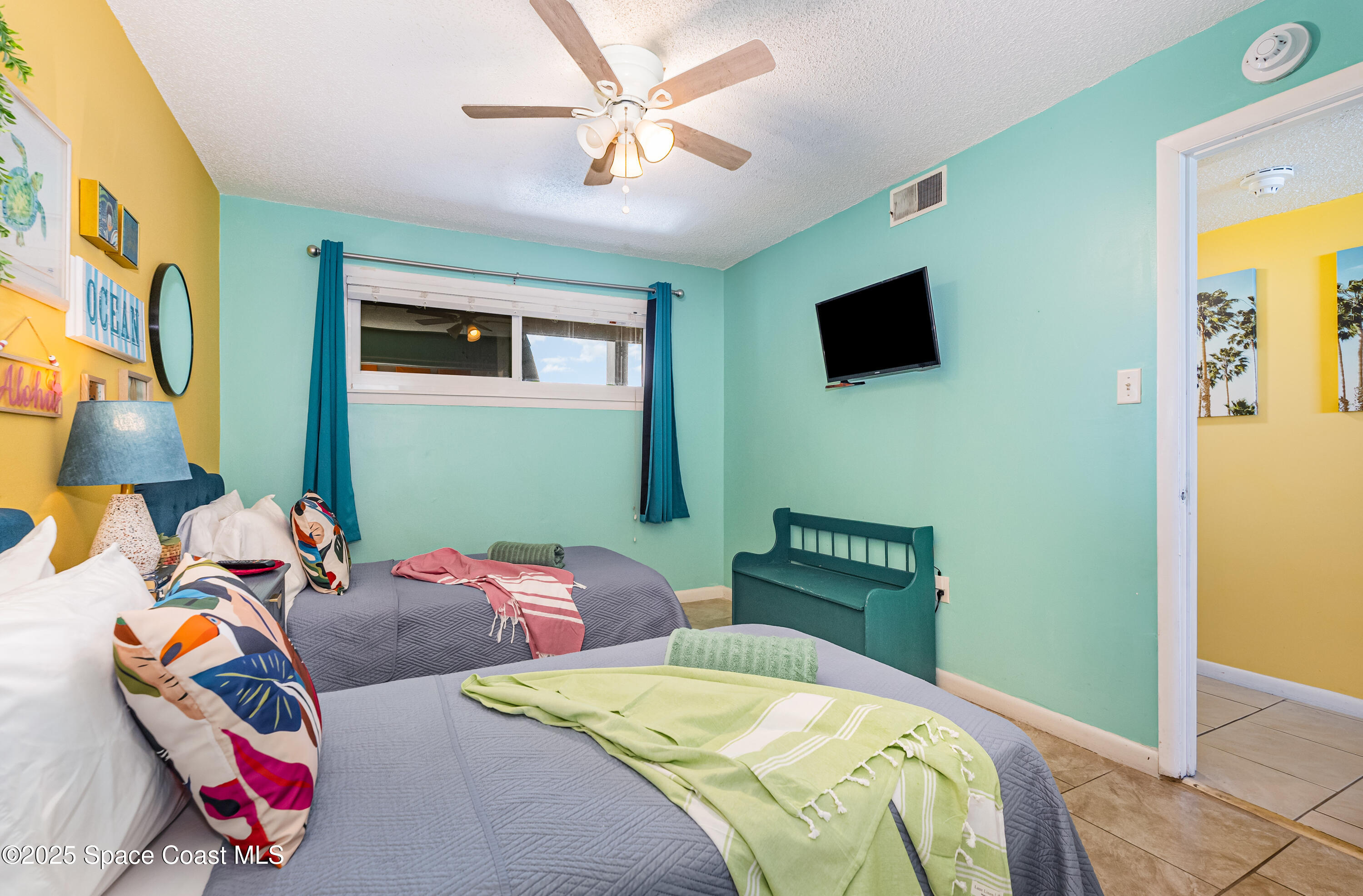 3150 North Atlantic Avenue, Unit 11550 Cocoa Beach, FL 32931 - Photo 16 of 30 a bedroom with a bed and a television