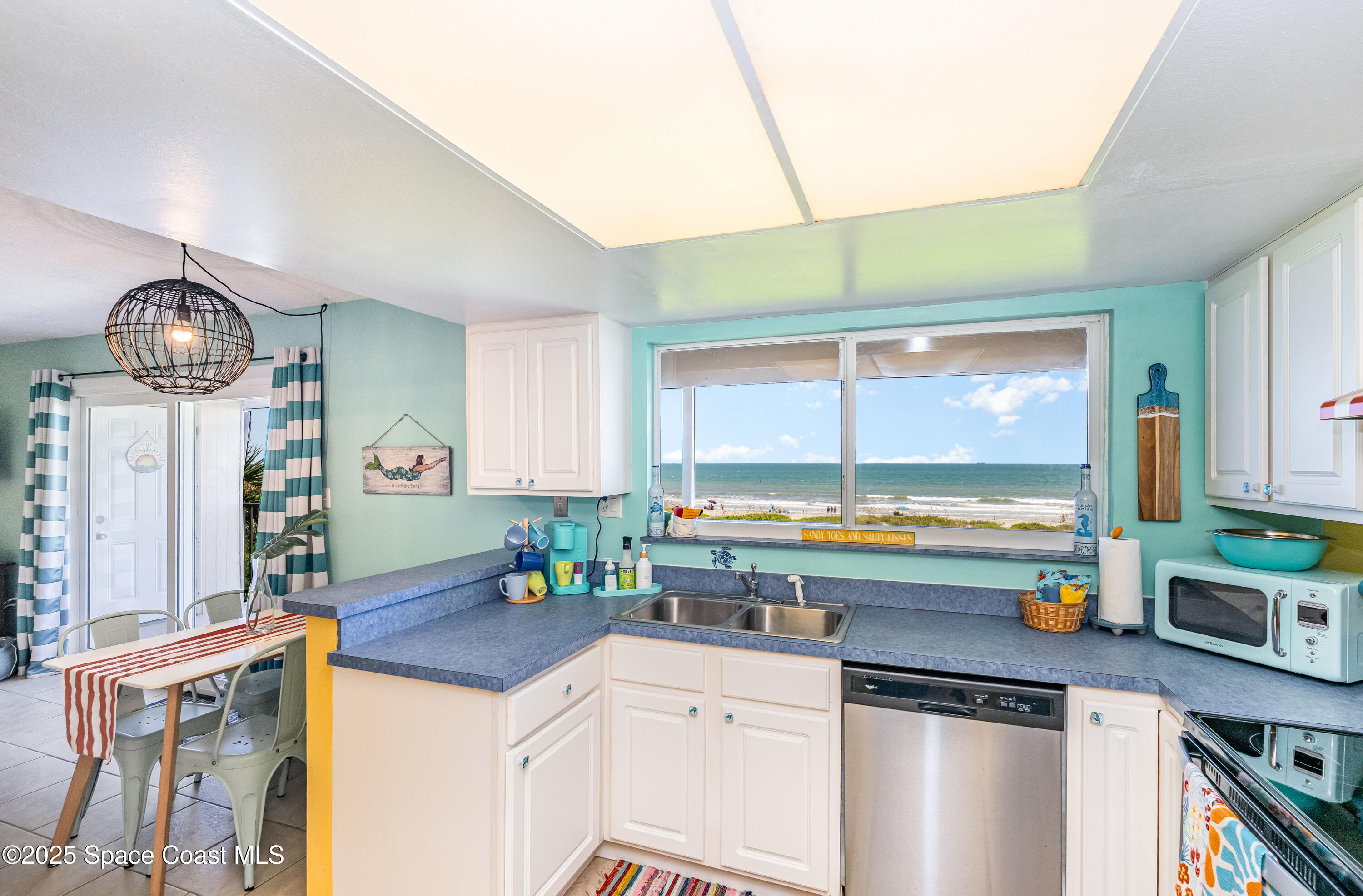 3150 North Atlantic Avenue, Unit 11550 Cocoa Beach, FL 32931 - Photo 4 of 30 a kitchen with a sink cabinets and window
