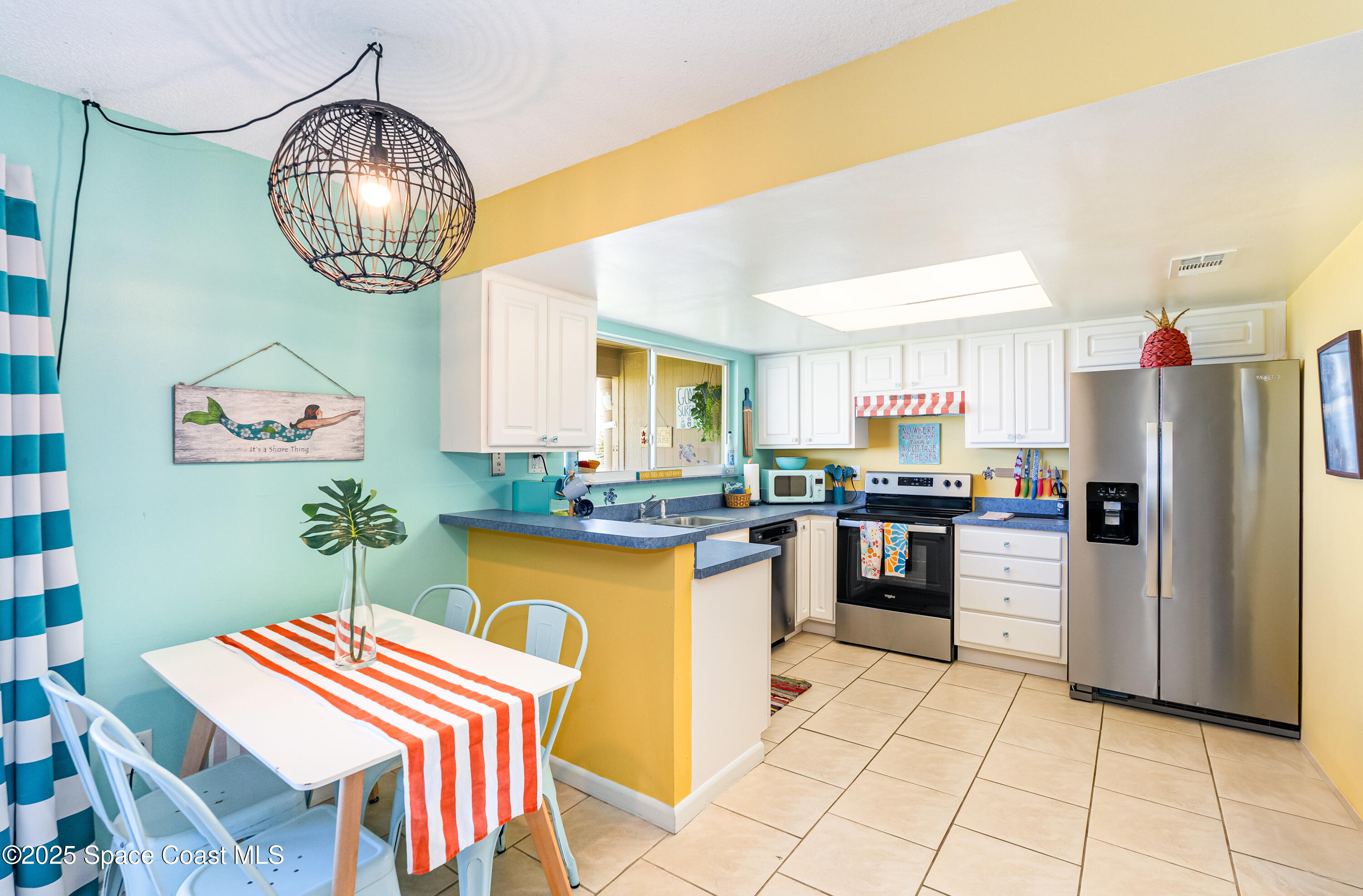 3150 North Atlantic Avenue, Unit 11550 Cocoa Beach, FL 32931 - Photo 6 of 30 a kitchen with a refrigerator a stove a sink and a dining table with garden view