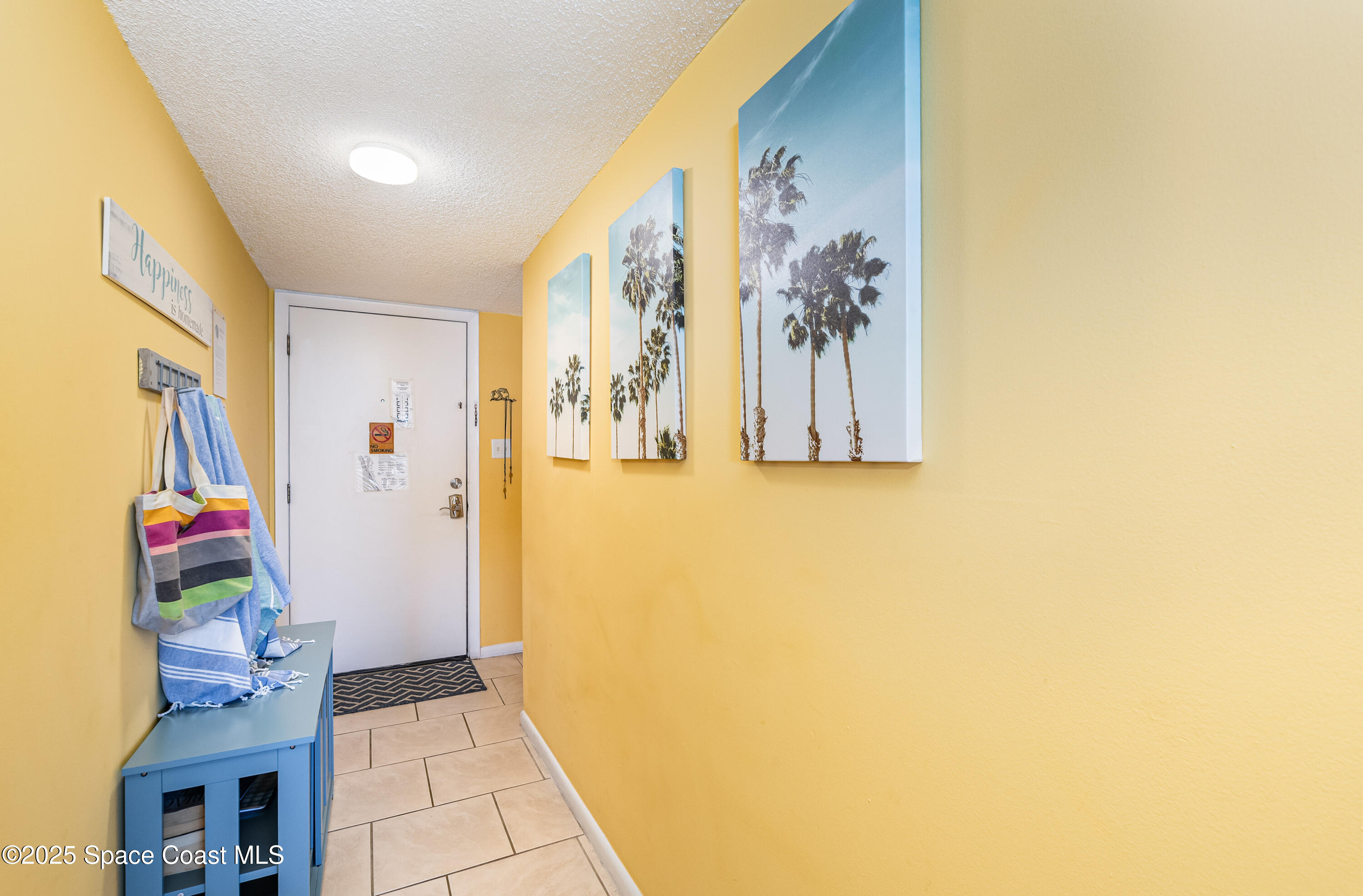 3150 North Atlantic Avenue, Unit 11550 Cocoa Beach, FL 32931 - Photo 10 of 30 a view of a hallway with paintings on the wall