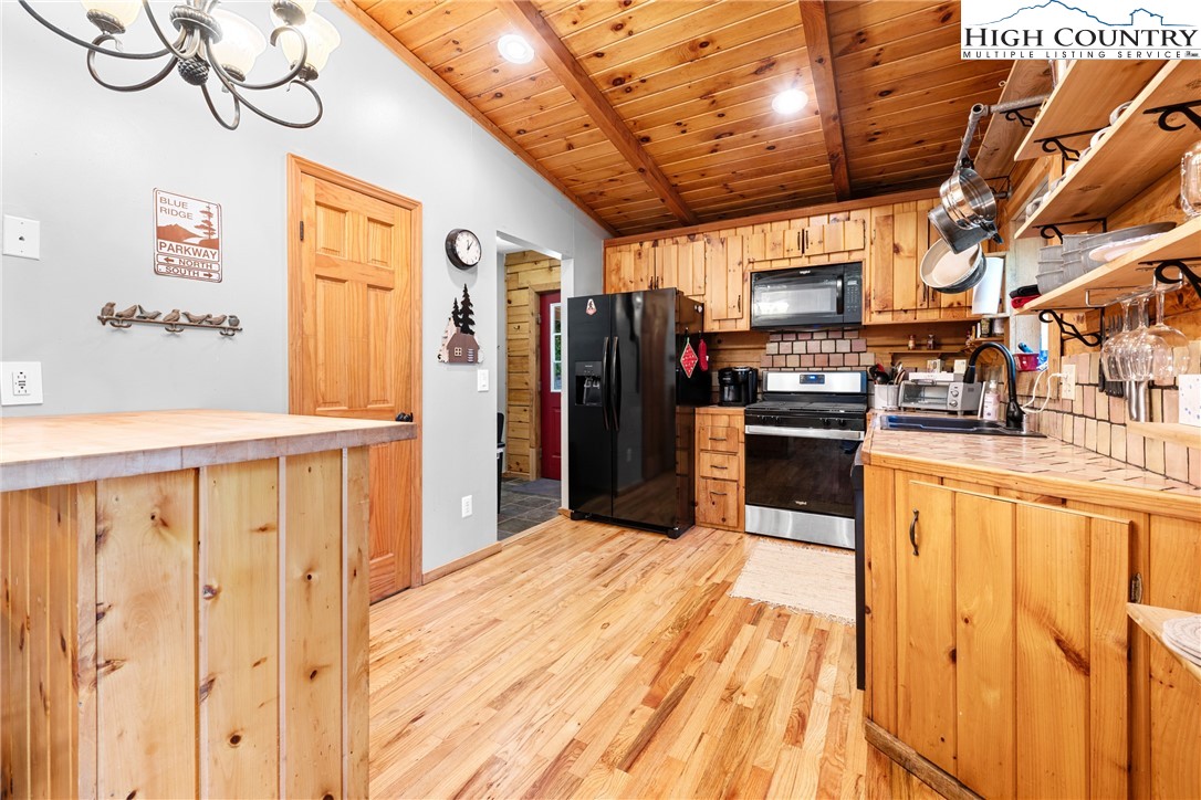 375 Winterberry Trail Boone, NC 28607 - Photo 11 of 36 a open kitchen with stainless steel appliances kitchen island granite countertop a refrigerator and wooden cabinets