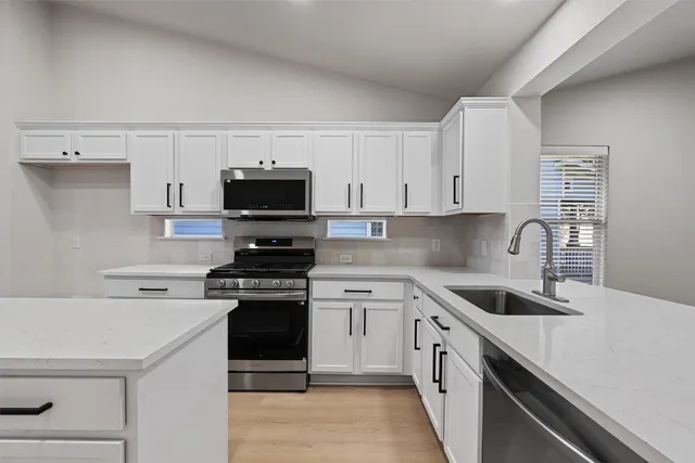 a kitchen with a sink and a stove top oven