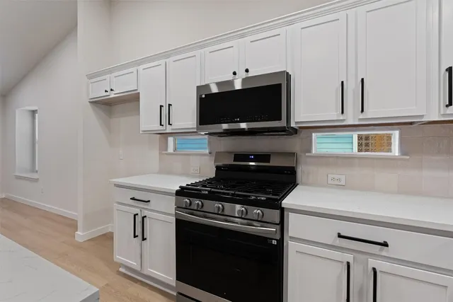 a kitchen with cabinets stainless steel appliances and a counter space