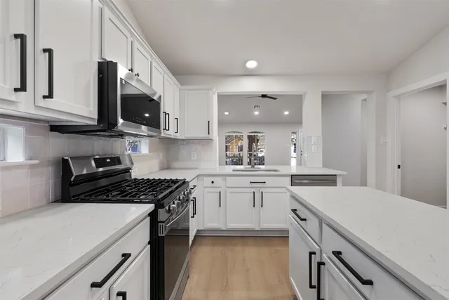 a kitchen with stainless steel appliances a sink stove and cabinets