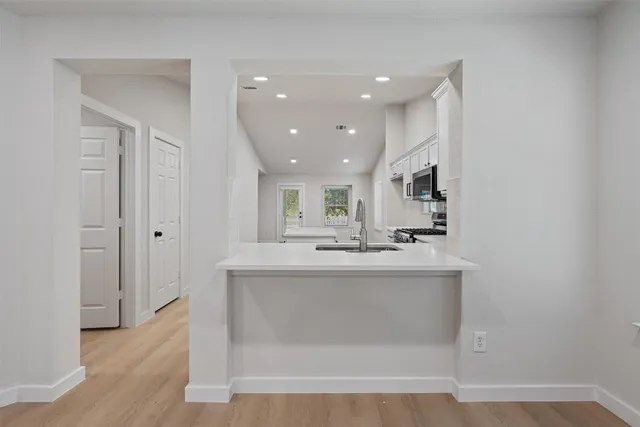 a view of kitchen with sink and refrigerator