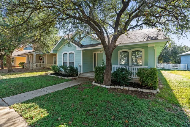 a front view of a house with a yard and potted plants
