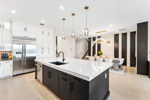 a kitchen with a dining table chairs cabinets and stainless steel appliances