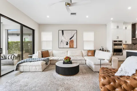 a living room with furniture kitchen view and a potted plant