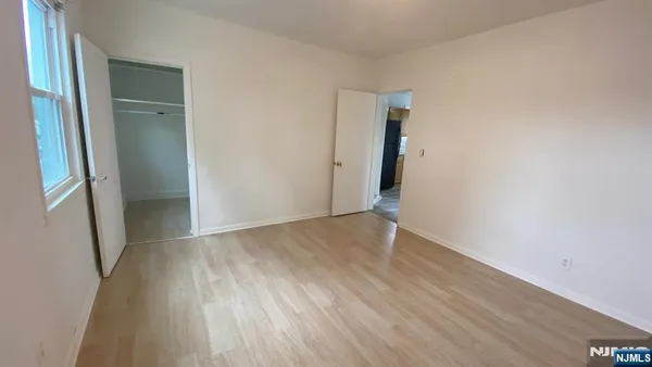 an empty room with wooden floor and an entrance