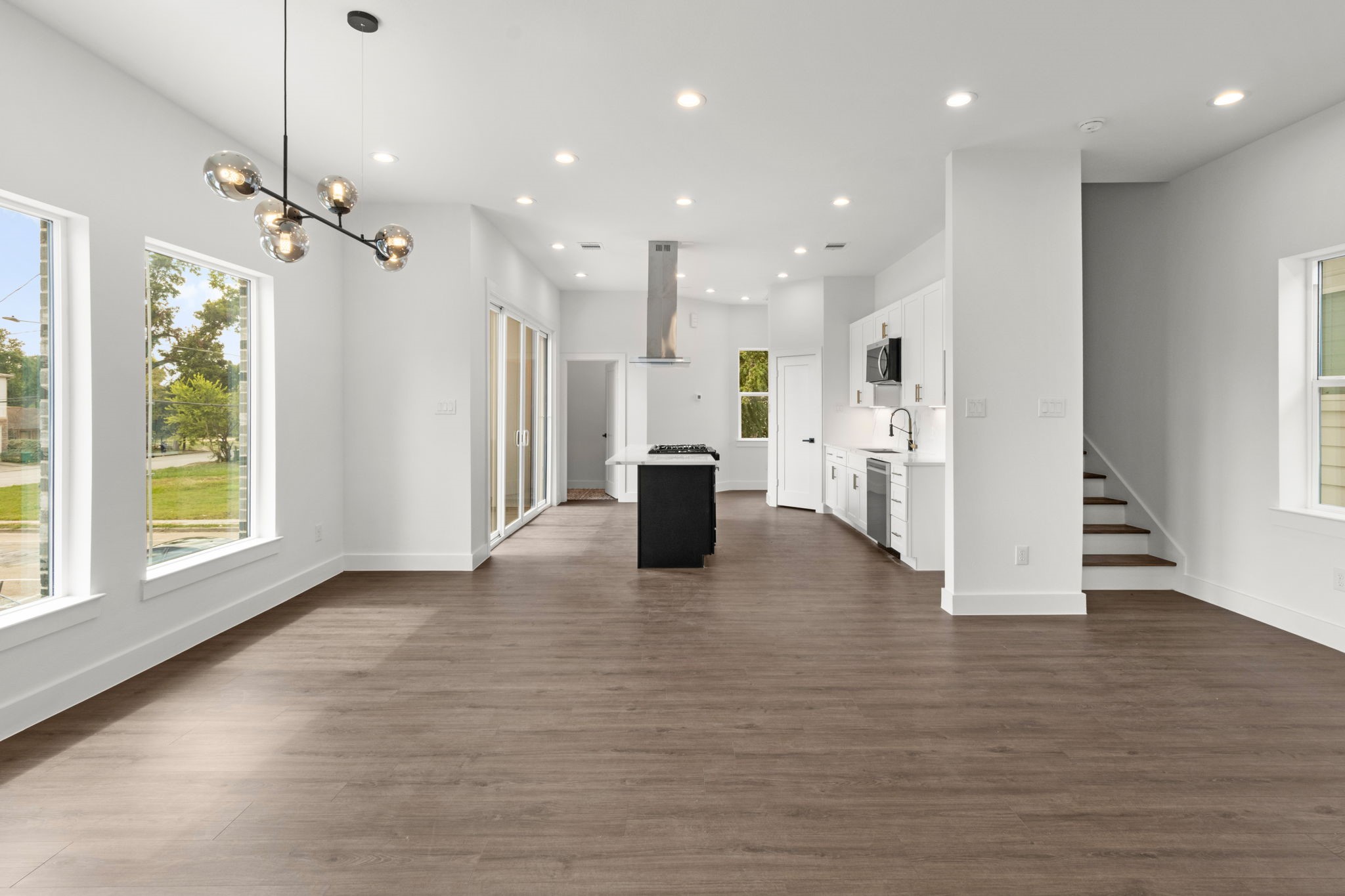 5512 Hardy Street Houston, TX 77009 - Photo 14 of 39 a view of an empty room and kitchen with wooden floor and windows
