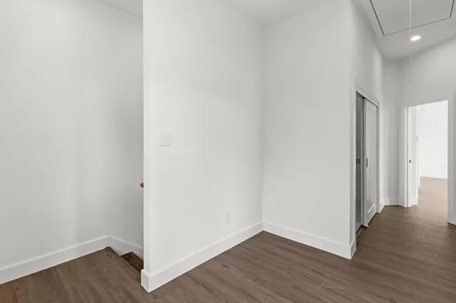 a view of an empty room with wooden floor