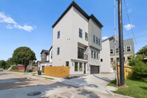a view of a white building among the street with palm trees