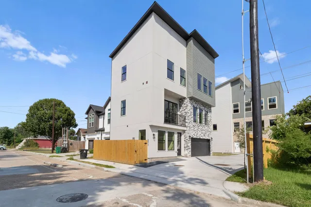 a view of a white building among the street with palm trees